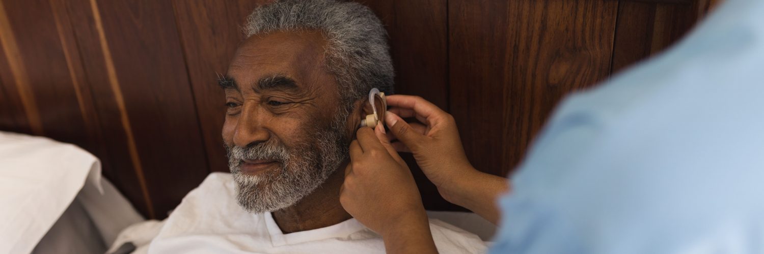 Mann mit Hörgerät im Bett